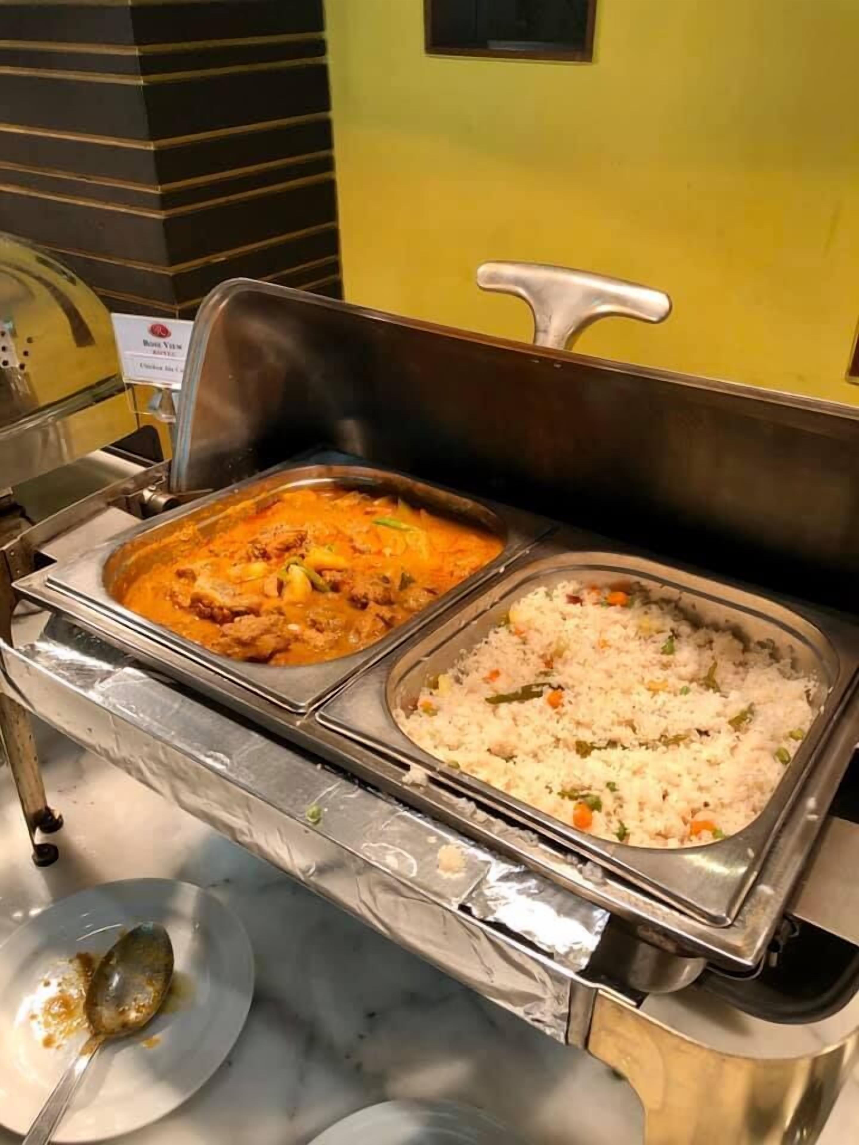 Un buffet proposant deux plats principaux : un curry et du riz.