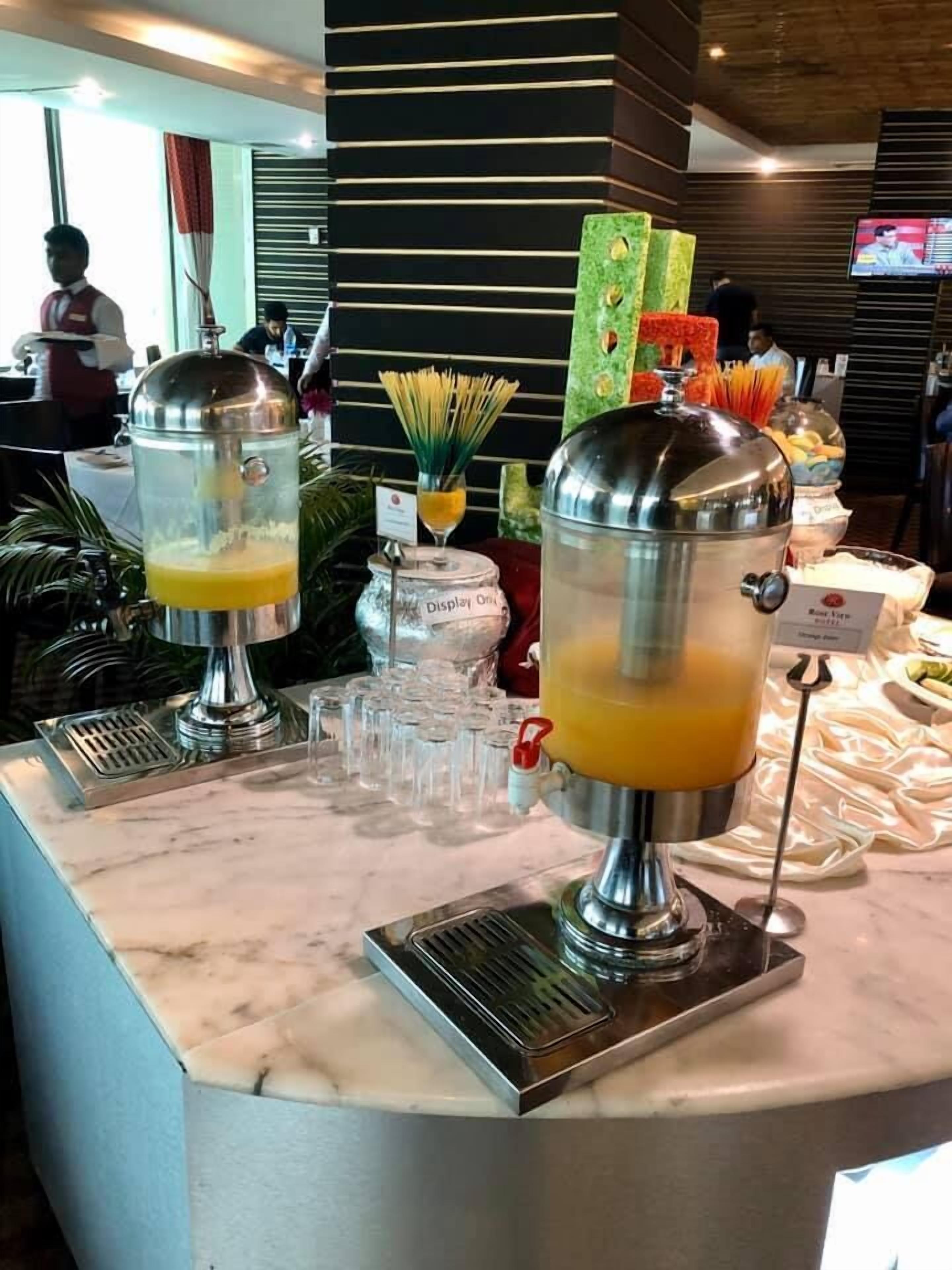 A buffet area with self-serve beverage dispensers and a variety of food items.