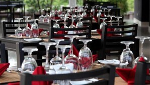 A restaurant with tables set with wine glasses and red napkins. - Magampura Eco Village Resort (Thissamaharama)