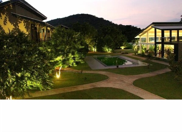 A courtyard with a central pool, surrounded by pathways and greenery, with buildings on either side. - Magampura Eco Village Resort (Thissamaharama)