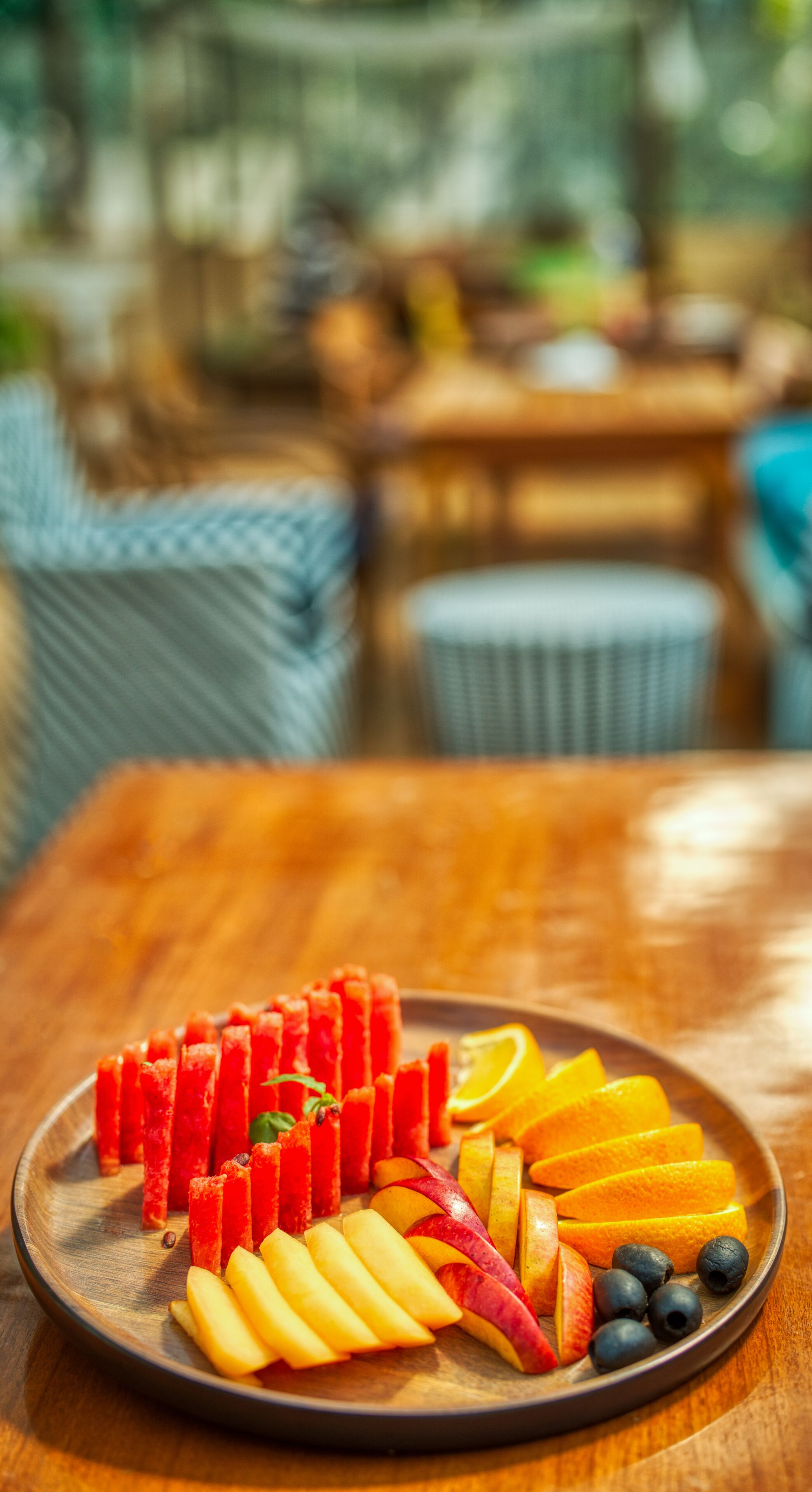 Une table en bois sur laquelle est disposée une assiette de fruits, le tout dans un cadre extérieur.