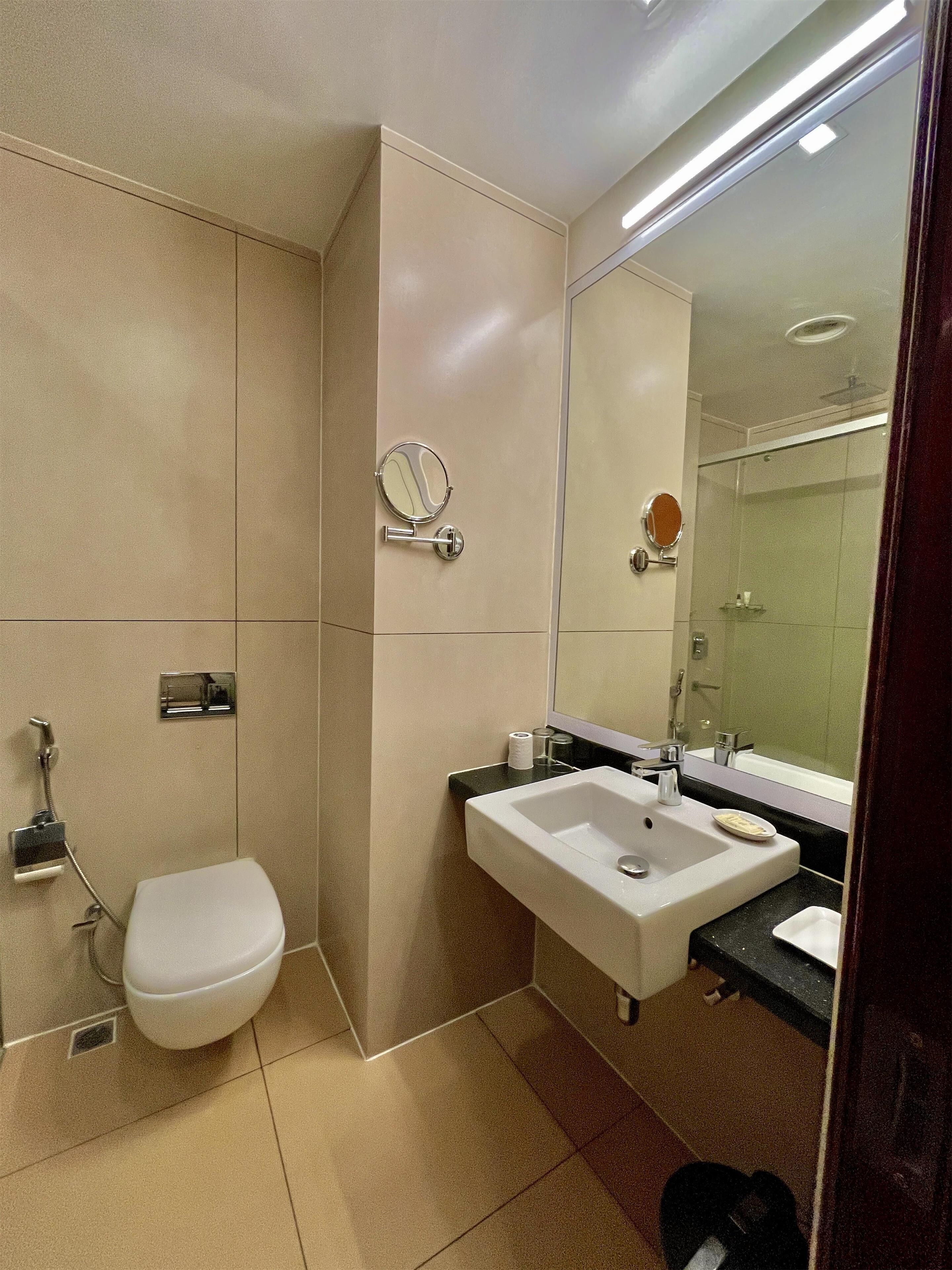 Ein modernes Badezimmer mit Toilette, Waschbecken und Spiegel.