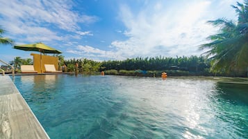 Een buitenzwembad, een infinity pool, ligstoelen bij het zwembad