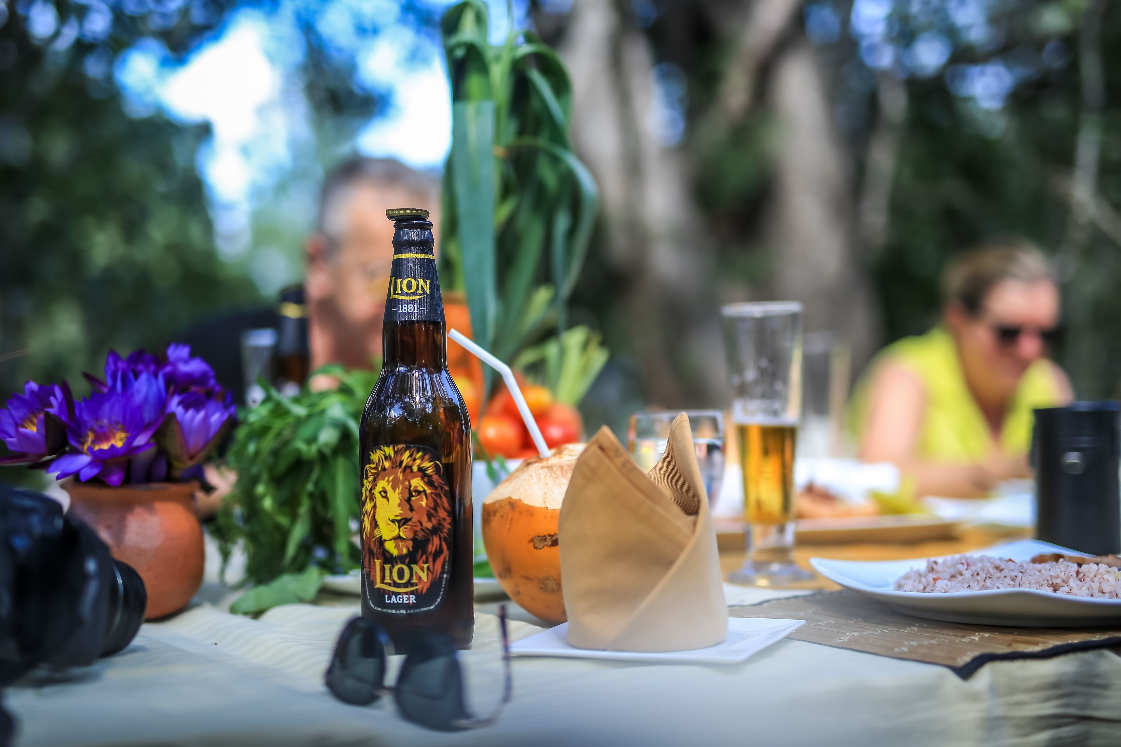 Una mesa con una botella de cerveza, un vaso y un plato de comida.