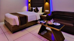 A modern hotel room with a bed, a sofa, a coffee table, and a ceiling fan. - Asia Pacific Hotel (Dhaka)