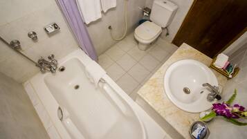 A bathroom with a bathtub, toilet, sink, and shower.