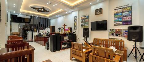 Un interior moderno con zona de comedor, muebles de madera, cocina y una pared decorada con carteles de viaje.