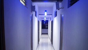 A long, narrow hallway with a shiny floor and walls painted in a light color. - Tex-Palazzo Hotel (Surat)