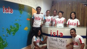 A group of people at a reception desk with a map and a thank you sign.