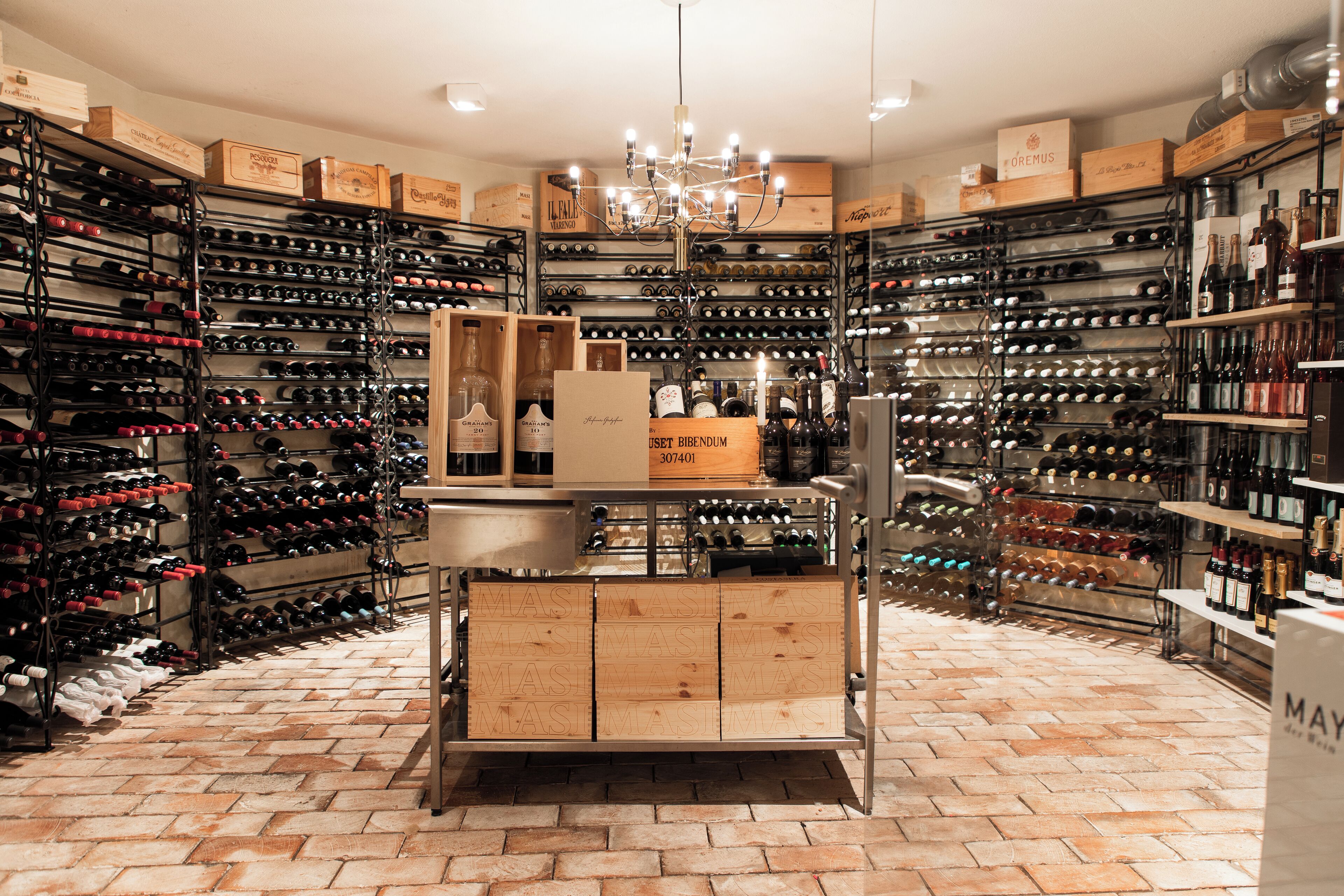 A wine cellar with multiple wine racks and wooden boxes.