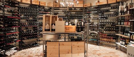 A wine cellar with multiple wine racks and wooden boxes.