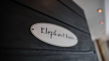 Un letrero sobre una superficie de madera oscura que dice 'Elephant Room'.