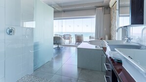 A modern bathroom with a large bathtub, a separate shower area, and a vanity with a sink.