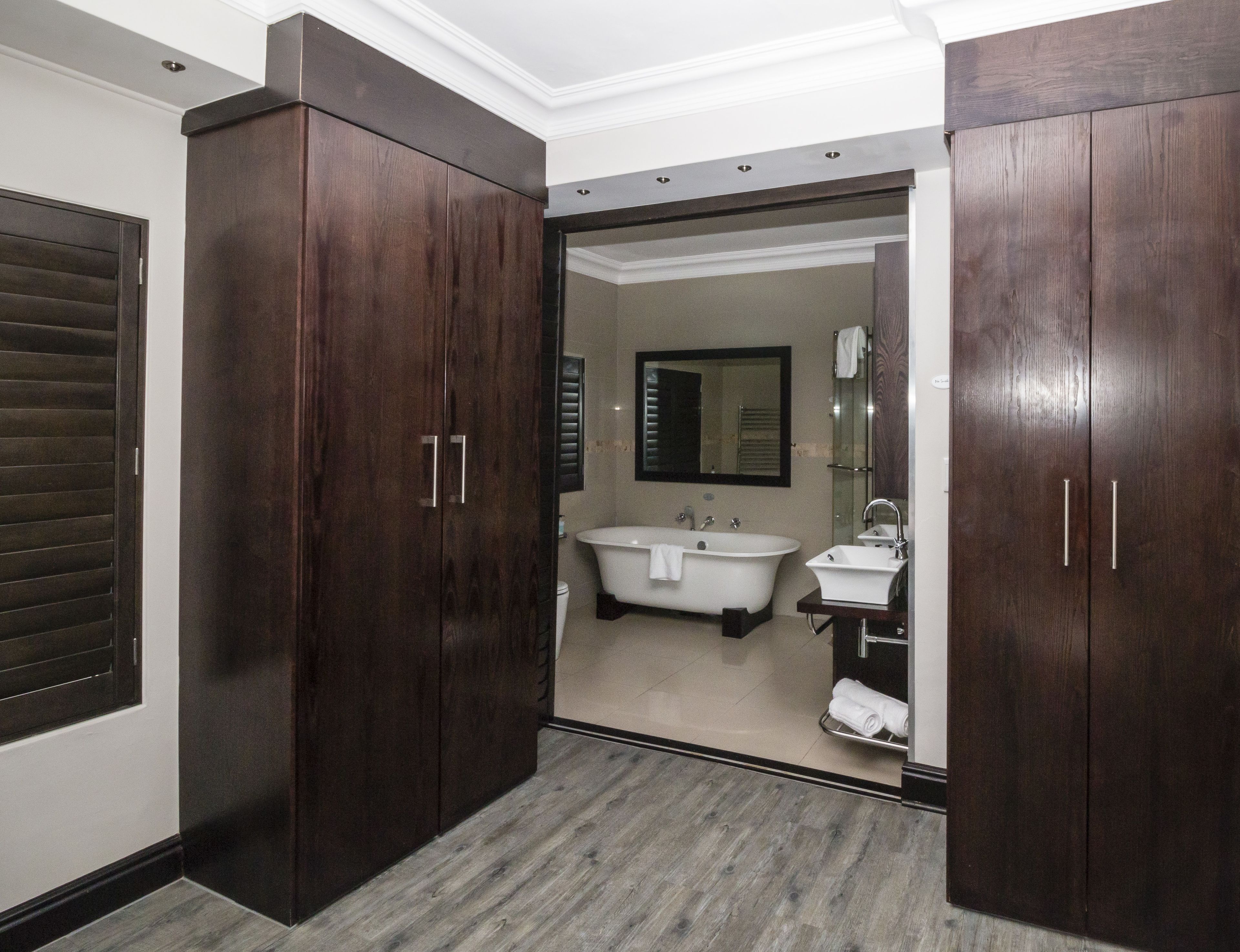A modern bathroom with a freestanding bathtub, a sink, and a mirror.