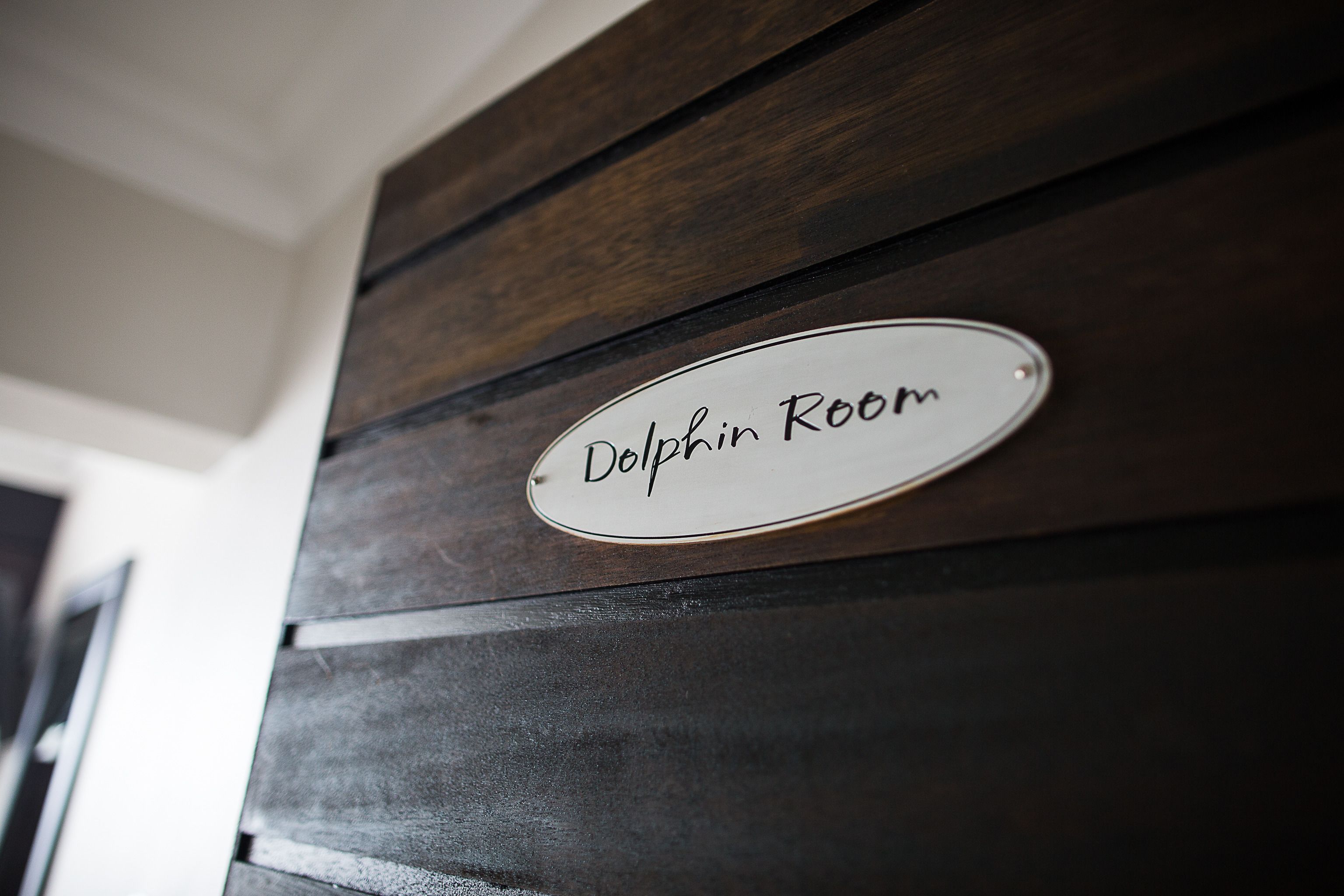 Un muro di legno con un cartello che indica 'Delphin Room'.