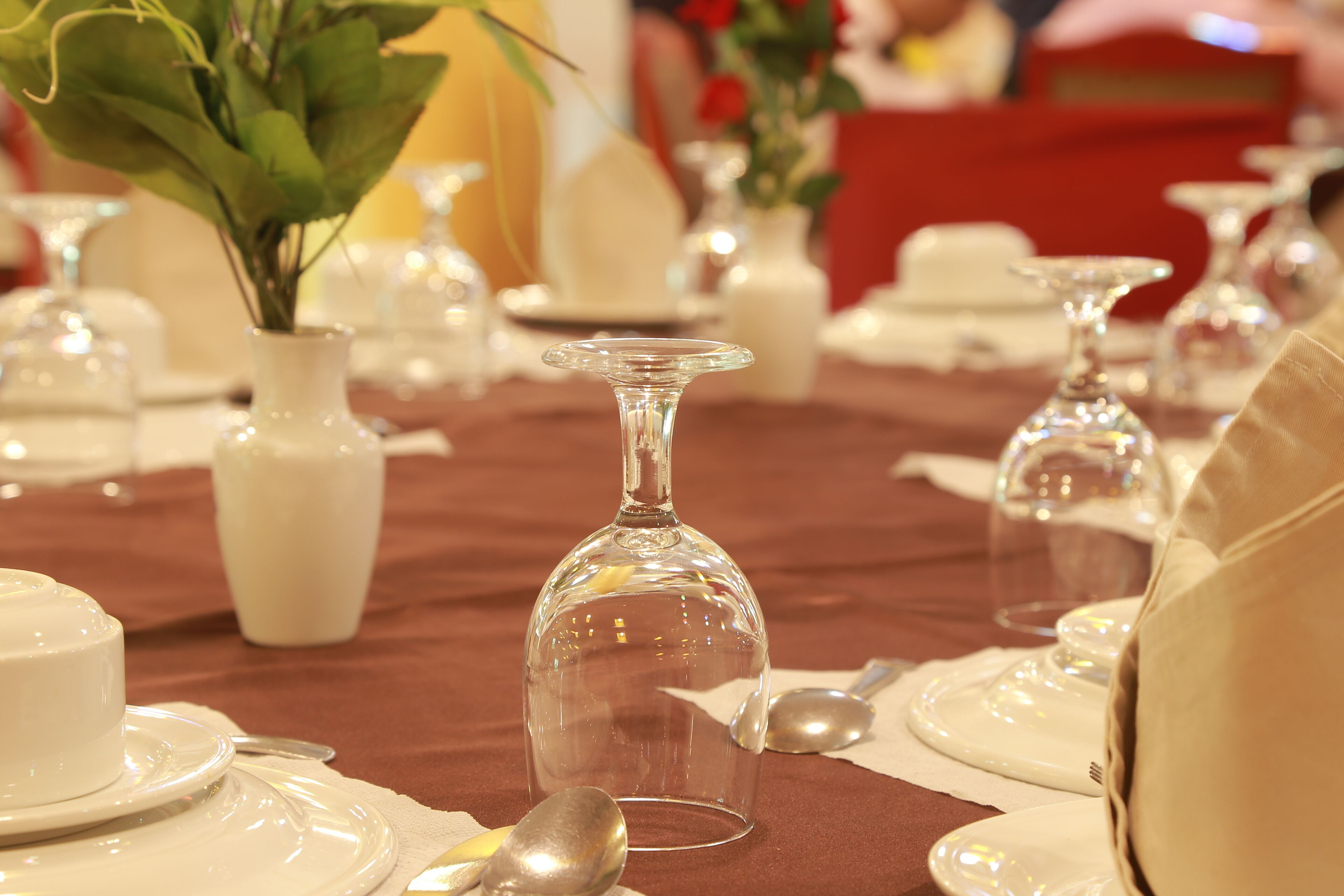 Een gedekte tafel met helder servies, witte borden en bestek.