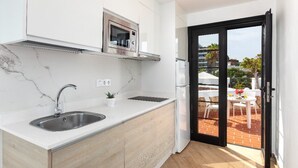 A compact kitchen with a sink, a microwave, and a small potted plant. - Los Cardones Boutique Village (Arona)