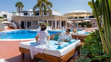 Een buitenzwembad en ligstoelen