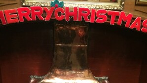 A fireplace with a metal hood and a red "MERRY CHRISTMAS" sign above it. - Nyton Hotel (Ely)