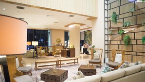 A spacious lobby with a modern design, featuring a seating area with sofas and chairs, a coffee table, and a decorative wall with plants. - Swiss-Belresidences Kalibata Jakarta (Jakarta)