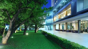 A modern building with multiple floors, large windows, and a well-maintained outdoor area with grass and trees. - Swiss-Belresidences Kalibata Jakarta (Jakarta)