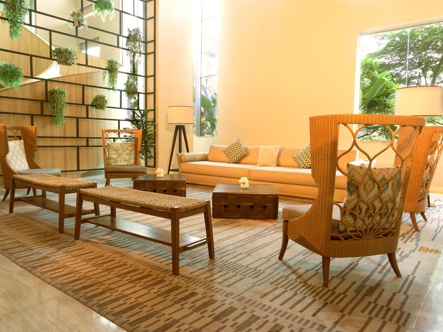 A modern living room with a sofa, two armchairs, a coffee table, and a patterned rug.