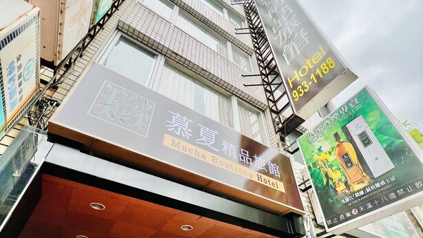 A hotel entrance with a sign indicating it is the Mucha Boutique Hotel. - Mucha Hotel (Yilan)
