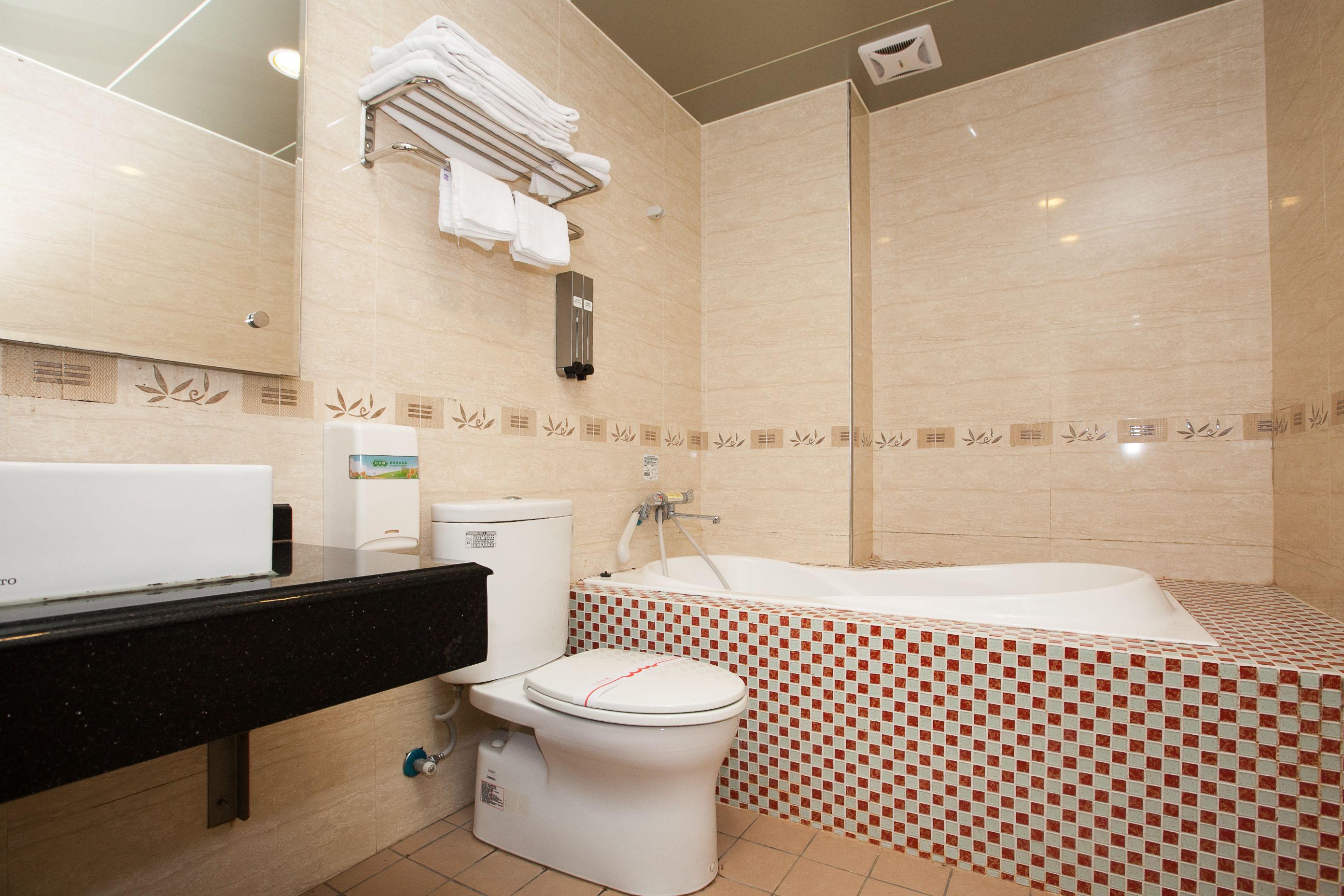 A modern bathroom with a toilet, sink, and bathtub.