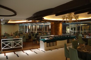 Un espace de restauration moderne, avec un buffet, des cloisons en verre et un mobilier contemporain.
