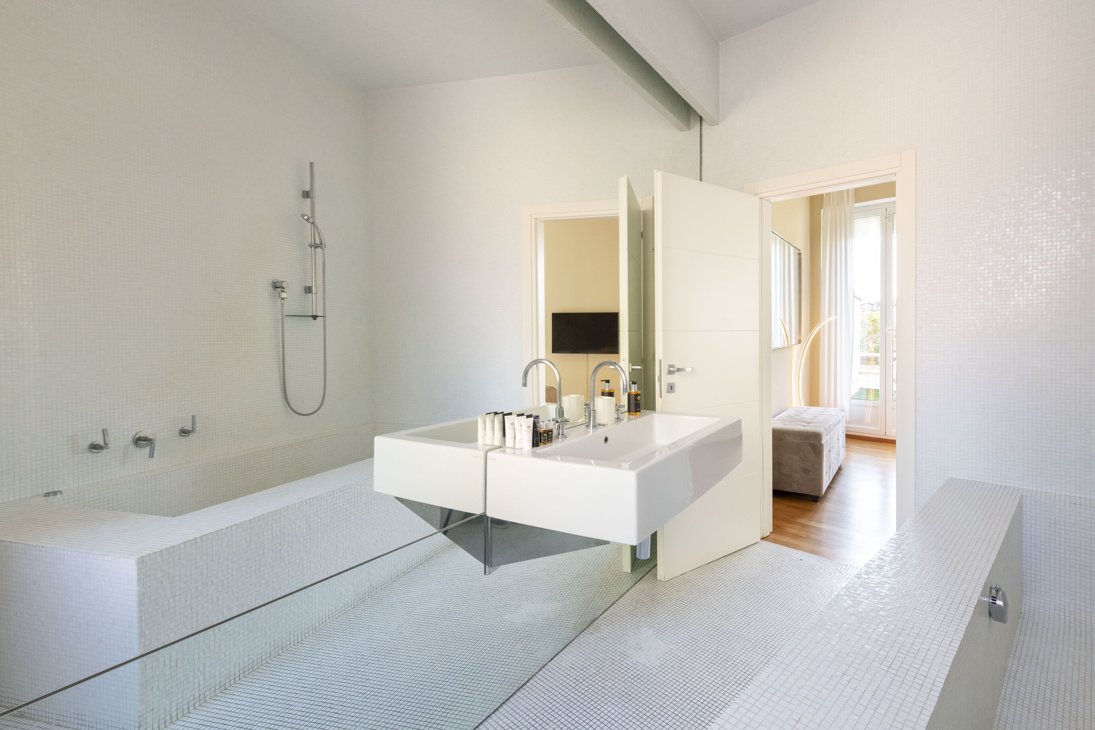 A modern bathroom with a large bathtub, a double sink, and a shower.