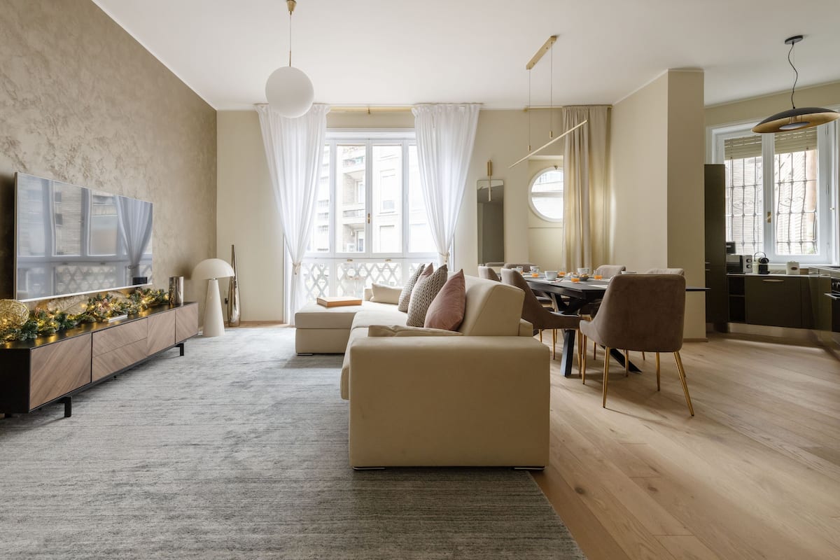 Una sala de estar moderna con sofá, mesa de comedor y área de cocina.