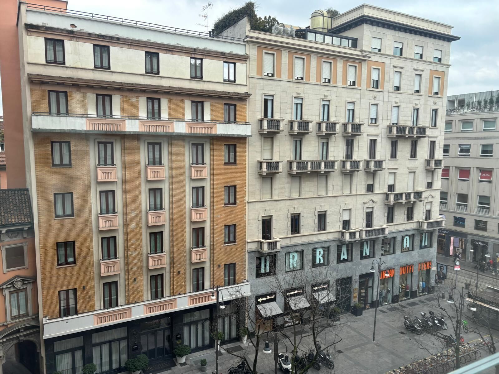 Un edificio de varios pisos con espacios residenciales y comerciales, con balcones, ventanas amplias y un escaparate en la planta baja.