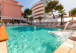 A swimming pool with lounge chairs and a water feature. - Hotel D'Annunzio (Jesolo)