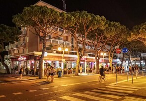 A nighttime street scene with a building featuring balconies and a pedestrian crossing. - Hotel D'Annunzio (Jesolo)