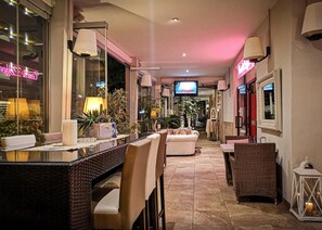 A hotel lobby with a bar area, seating, and a television. - Hotel D'Annunzio (Jesolo)