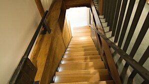 Una escalera de madera con barandilla de metal que conduce a un piso superior.