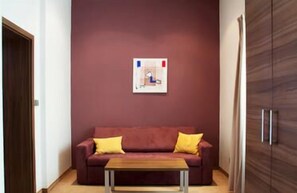 Departamento Deluxe, 1 habitación | Área de sala de estar | Televisión de pantalla plana 
