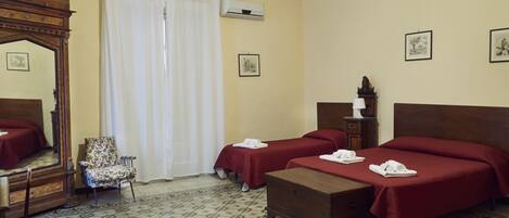Habitación de hotel con dos camas, un aparador de madera, una silla y un espejo.