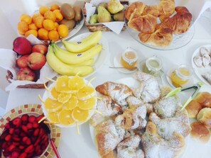 A table with various food items including fruits, pastries, and condiments. - Alloggio della Posta Vecchia (Agrigento)
