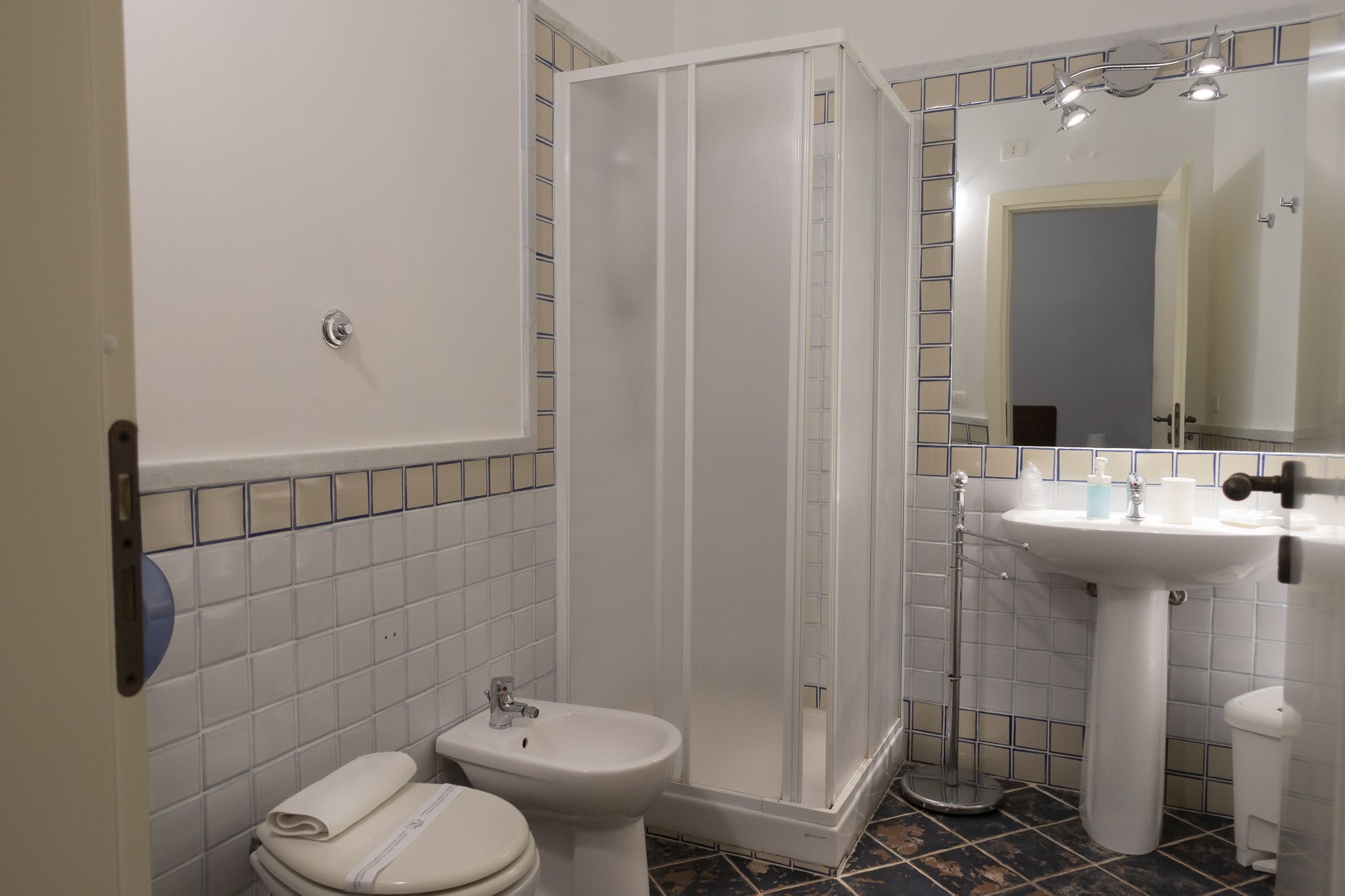 Une salle de bain équipée d’une douche, de toilettes, d’un bidet et d’un lavabo.