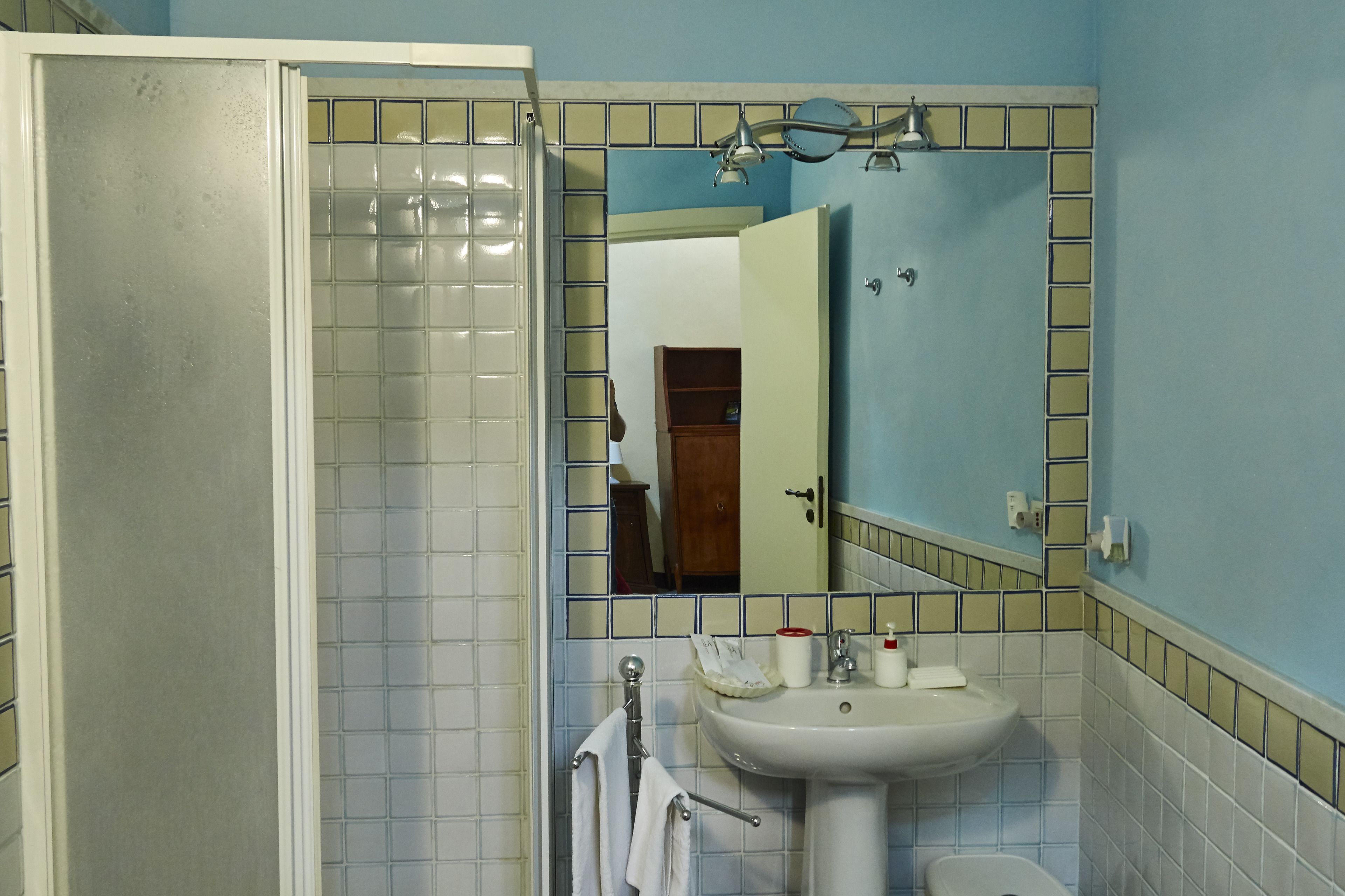 A bathroom with a shower, sink, and mirror.
