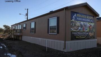 A single-story building with a sign advertising private rooms and food included.
