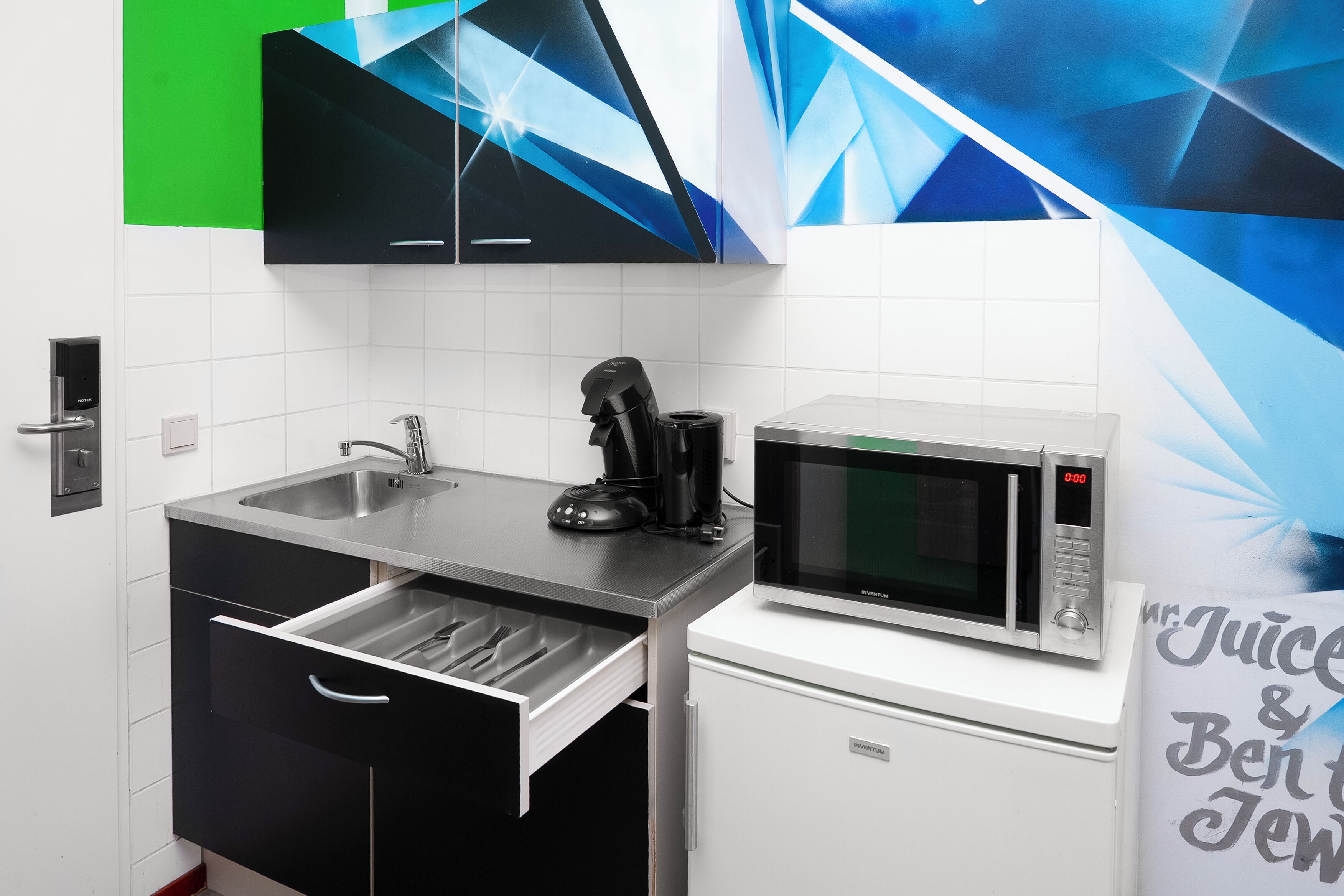 A modern kitchen with a microwave, coffee maker, and a sink.