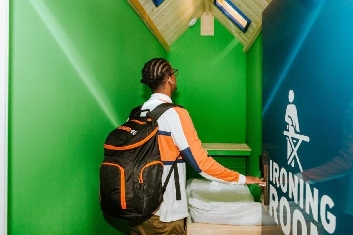 A person in a green room with a sign for an ironing room.