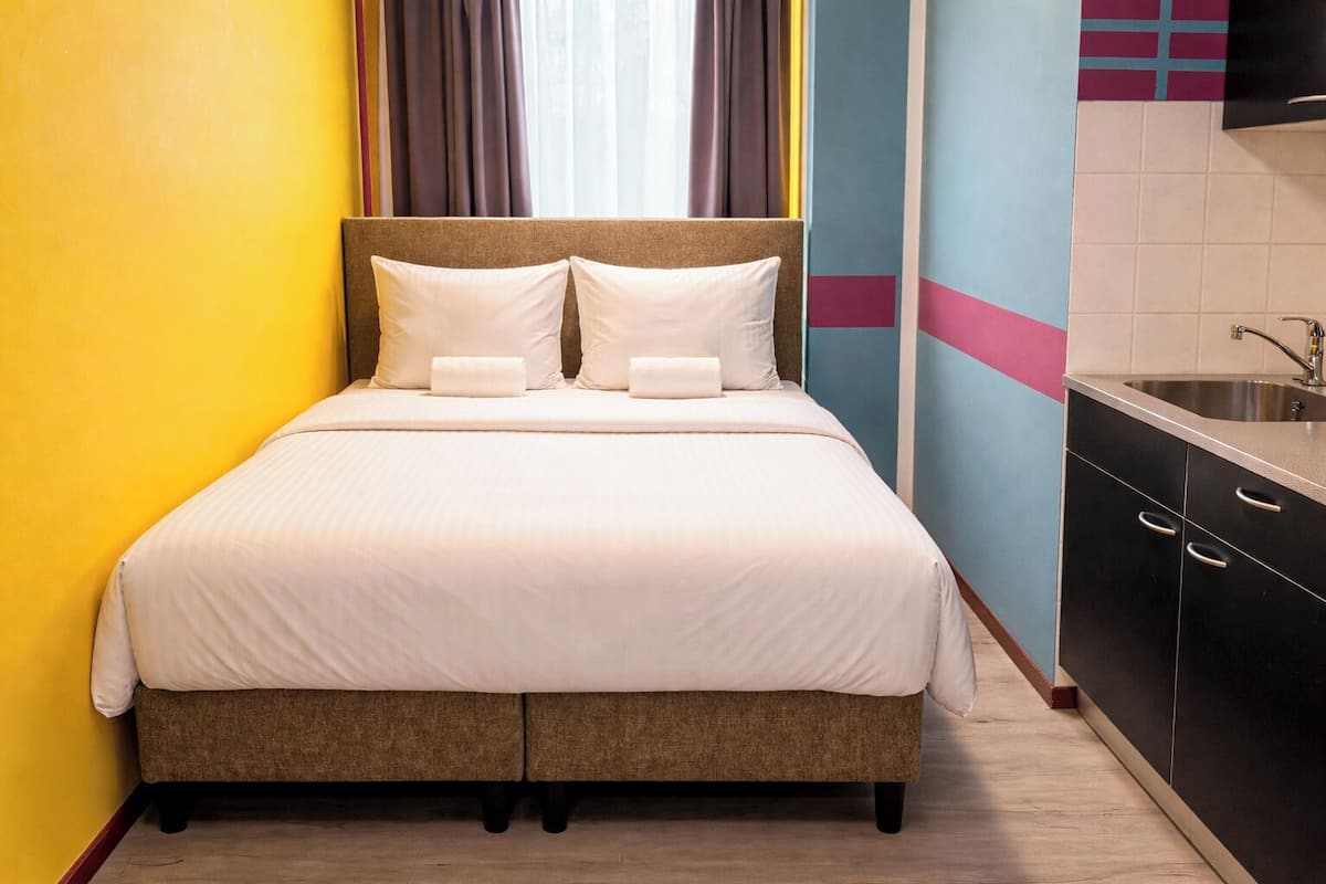 A bed with white bedding, a headboard, and two pillows.