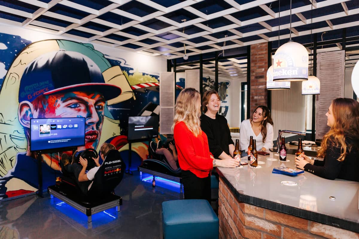 A bar area with a counter, seating, and a mural on the wall.