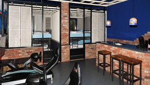 A modern bar area with a brick wall, a counter, and bar stools. - Amsterdam Teleport Hotel (Amsterdam)