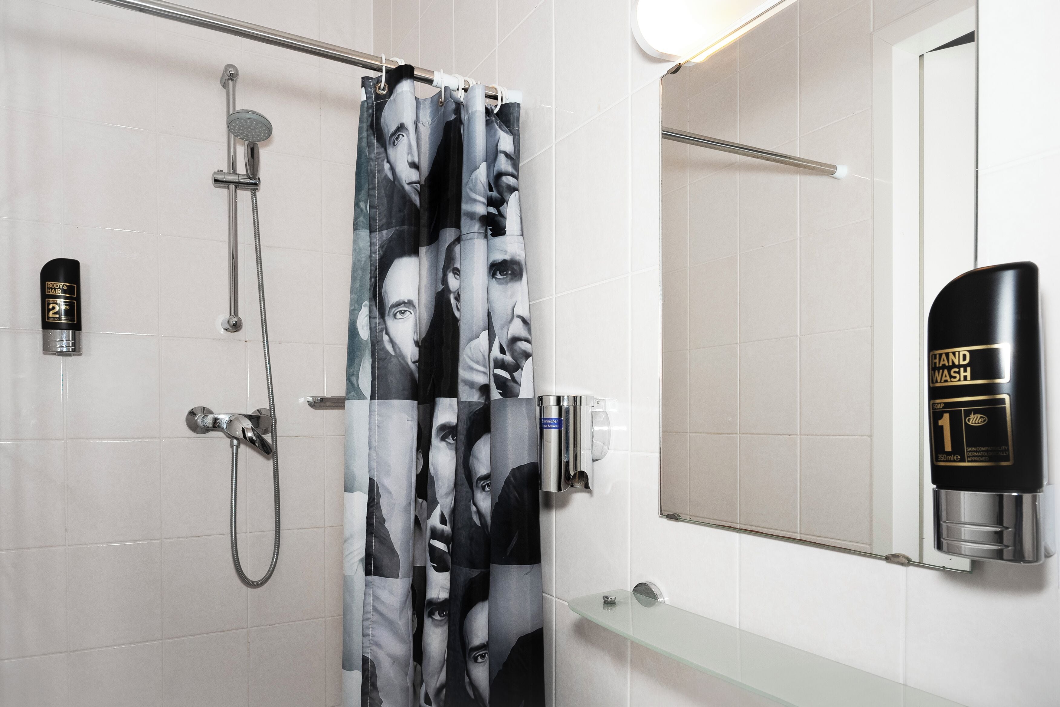 Een badkamer met een douche, een wastafel en een glazen plank.