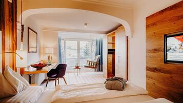 Une chambre d’hôtel avec un lit, un bureau, une chaise et une vue sur l’extérieur.