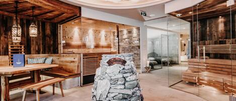 A restaurant with wooden interiors, a stone centerpiece, and a ceiling with a starry design.